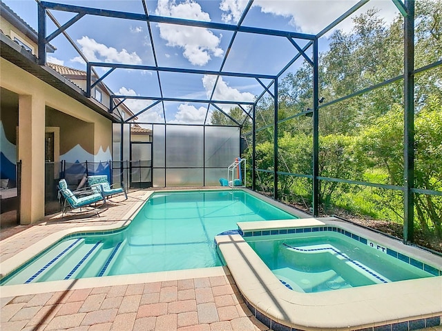 view of pool featuring glass enclosure, an in ground hot tub, and a patio area