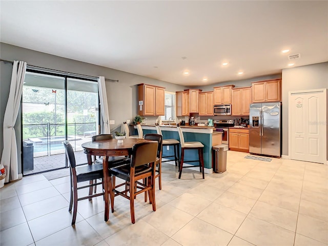 tiled dining room featuring sink and a healthy amount of sunlight