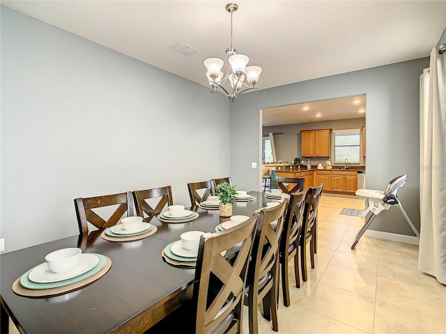 tiled dining space with a chandelier and sink