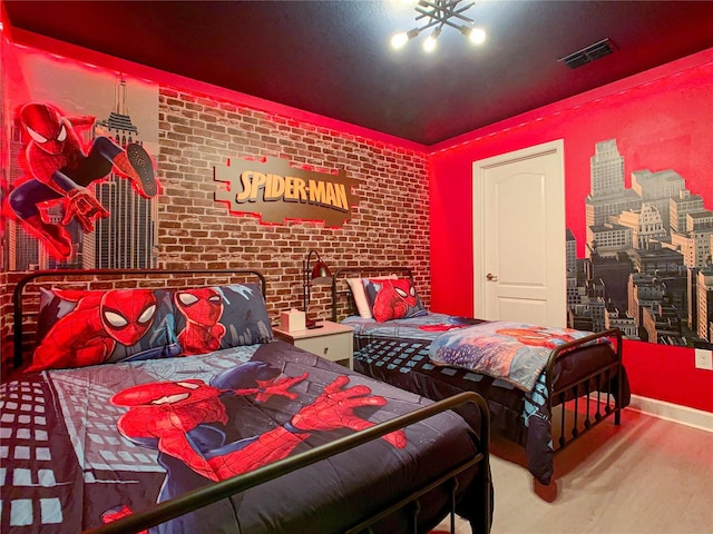 bedroom featuring brick wall