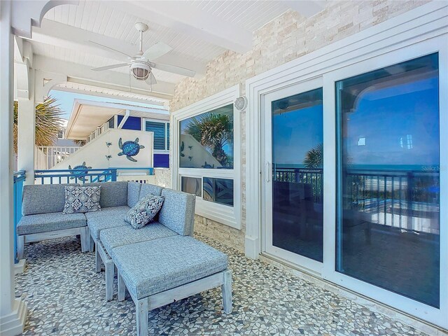 sunroom featuring beamed ceiling and ceiling fan