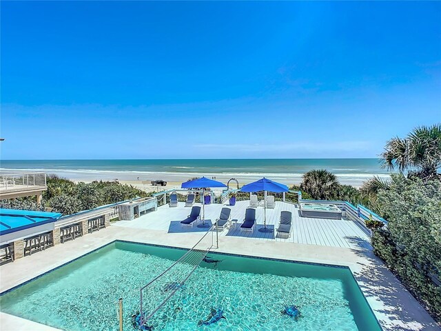 view of pool featuring a view of the beach, a patio, and a water view