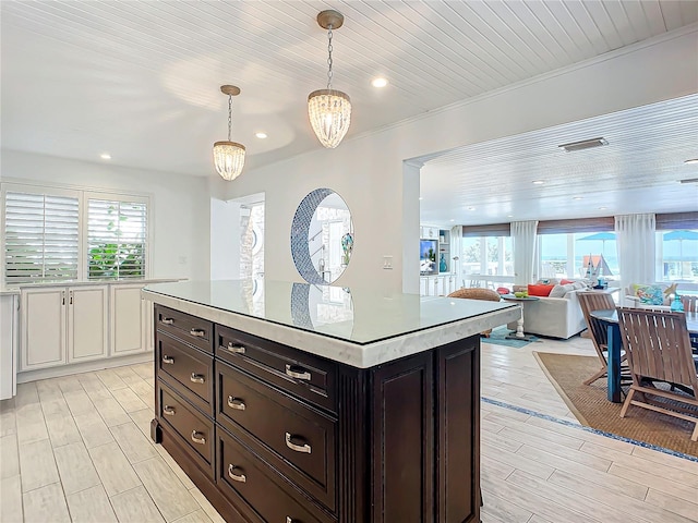 kitchen with light wood-type flooring, white cabinets, pendant lighting, and a wealth of natural light