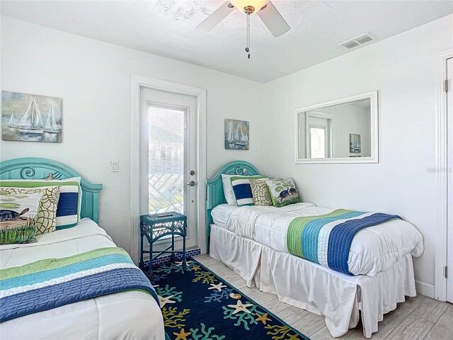 bedroom with multiple windows, light hardwood / wood-style flooring, access to exterior, and ceiling fan