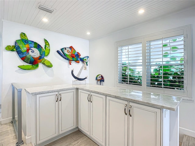 kitchen featuring light hardwood / wood-style flooring, a wealth of natural light, and light stone counters