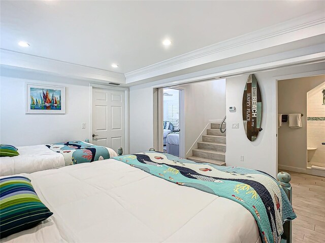 bedroom with a closet, ensuite bathroom, and light hardwood / wood-style flooring