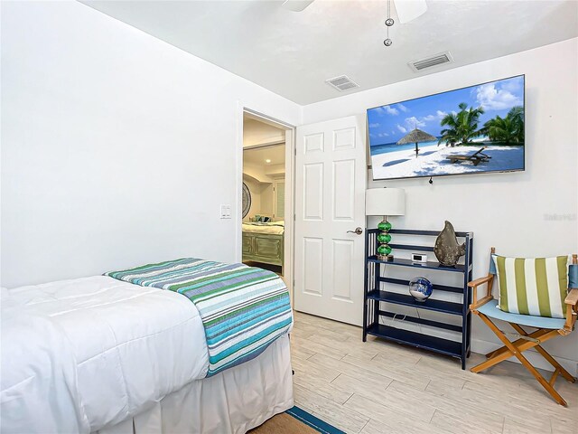 bedroom featuring light hardwood / wood-style flooring, ceiling fan, and connected bathroom