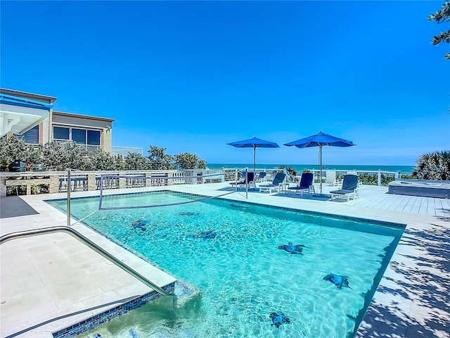 view of pool with a water view and a patio