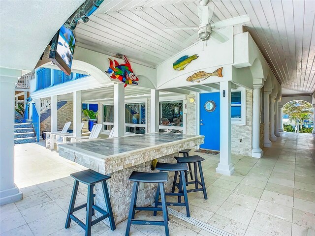 view of patio with an outdoor bar and ceiling fan