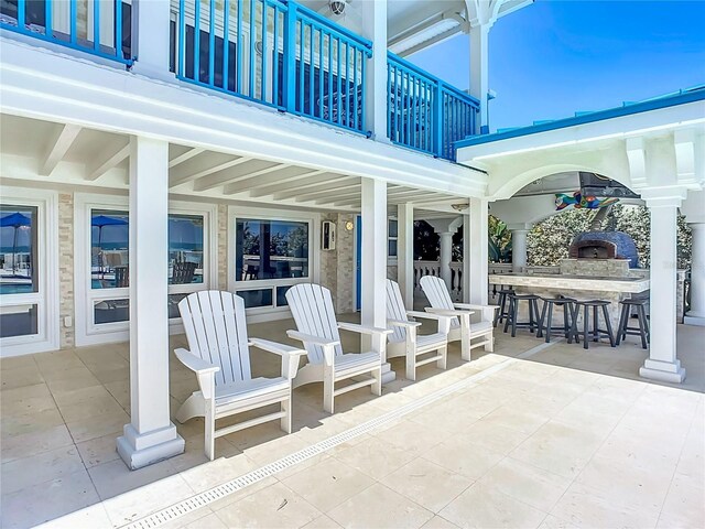 view of patio / terrace featuring a balcony, an outdoor bar, and area for grilling