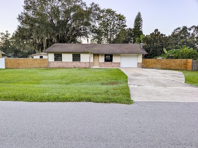 ranch-style house with a garage and a front lawn