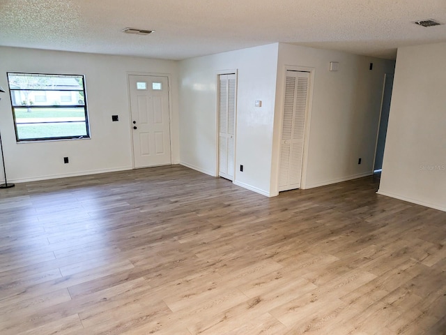 entrance foyer featuring a textured ceiling and light hardwood / wood-style floors