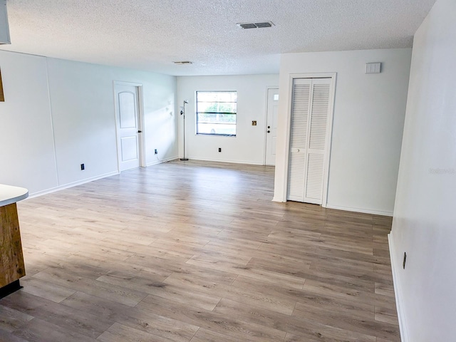 empty room featuring light hardwood / wood-style floors and a textured ceiling