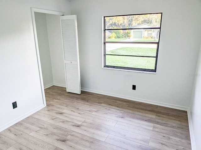 unfurnished bedroom with light wood-type flooring and a closet