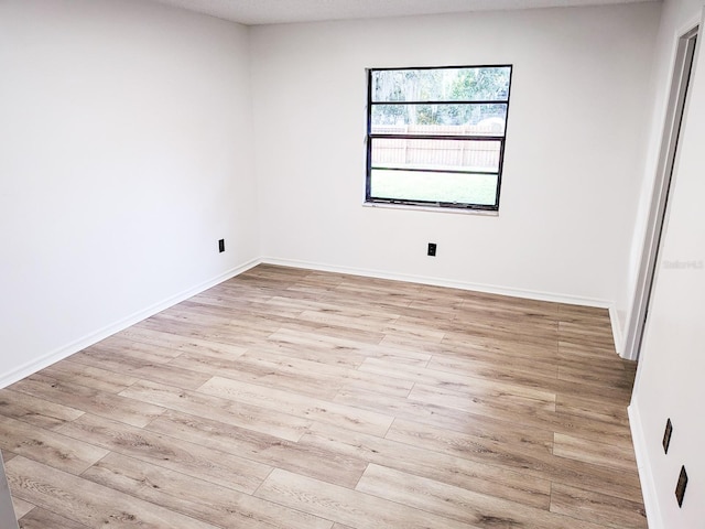 spare room featuring light hardwood / wood-style flooring and a textured ceiling