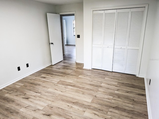 unfurnished bedroom featuring a closet and light wood-type flooring