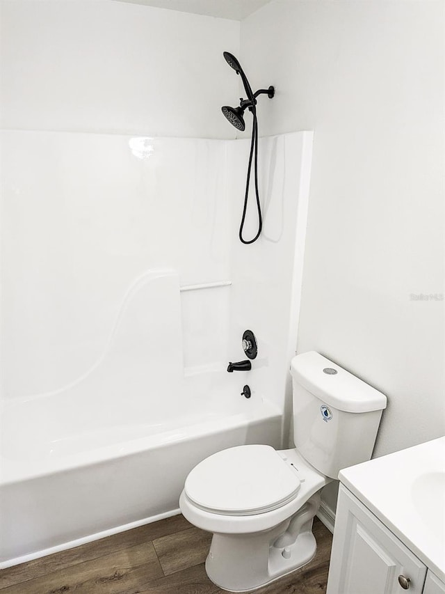 full bathroom featuring shower / washtub combination, hardwood / wood-style flooring, vanity, and toilet