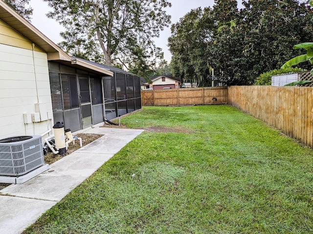 view of yard with a sunroom and central air condition unit