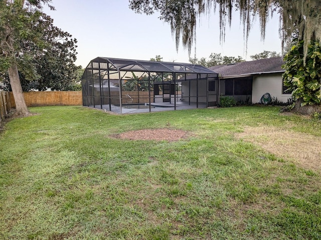 view of yard with glass enclosure, a patio, and a swimming pool