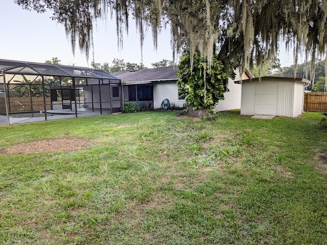 view of yard featuring glass enclosure, a storage shed, a patio, and a swimming pool