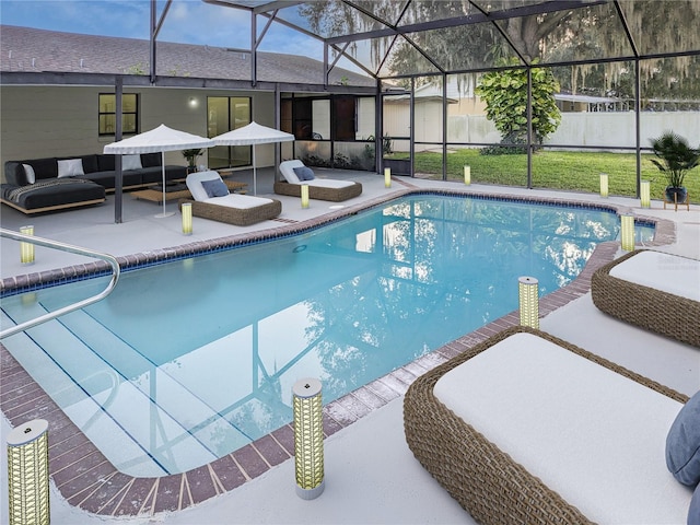 view of pool featuring a lanai, a patio area, and a lawn