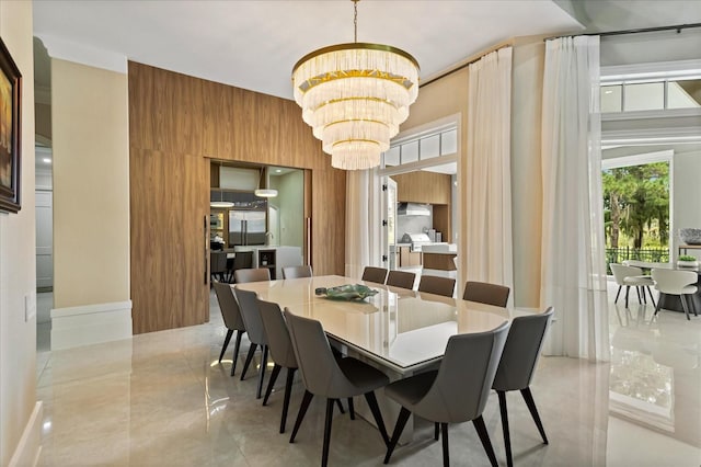 dining space with wooden walls and a chandelier