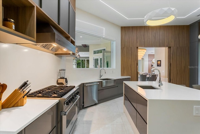 kitchen featuring light tile patterned floors, appliances with stainless steel finishes, sink, wall chimney range hood, and a kitchen island with sink