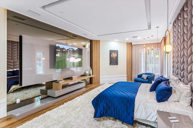 bedroom featuring a tray ceiling and wood-type flooring