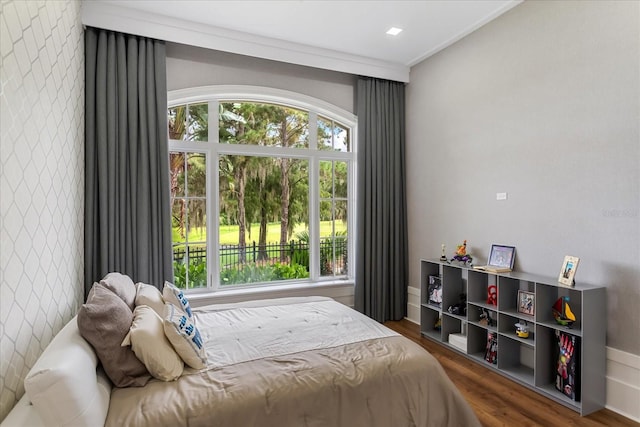 bedroom featuring multiple windows, dark hardwood / wood-style flooring, and ornamental molding