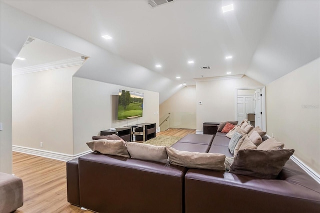 living room with light wood-type flooring, vaulted ceiling, and ornamental molding