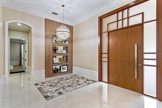 foyer entrance with a notable chandelier and ornamental molding