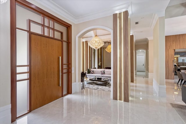 foyer featuring wooden walls, a chandelier, and ornamental molding