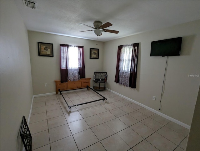 unfurnished room with light tile patterned floors and ceiling fan