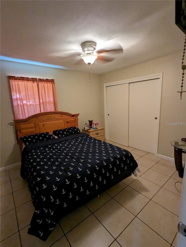 bedroom with a closet, ceiling fan, and light tile patterned flooring