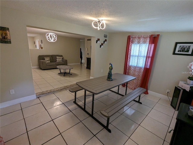 tiled dining area featuring a textured ceiling