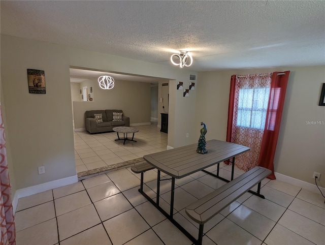 tiled dining space featuring a textured ceiling