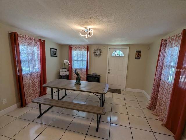 tiled dining area featuring a textured ceiling