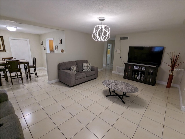 tiled living room with a chandelier and a textured ceiling