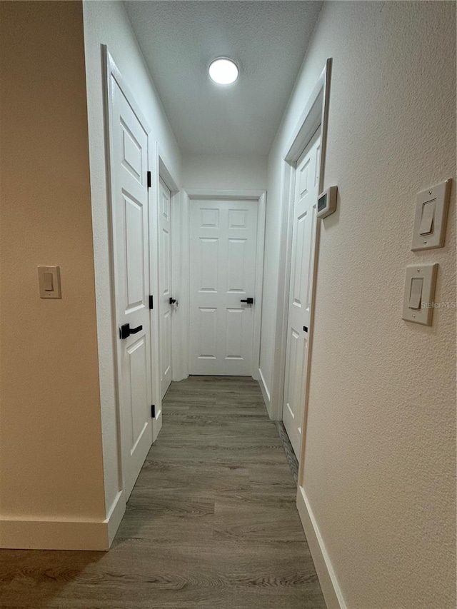 corridor with hardwood / wood-style floors