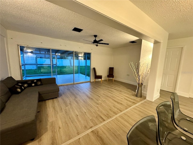 living room with ceiling fan, hardwood / wood-style floors, and a textured ceiling