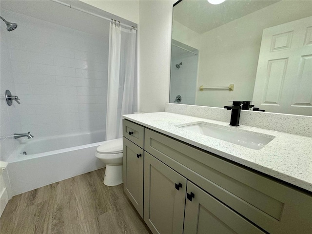 full bathroom featuring hardwood / wood-style floors, vanity, toilet, and shower / tub combo with curtain