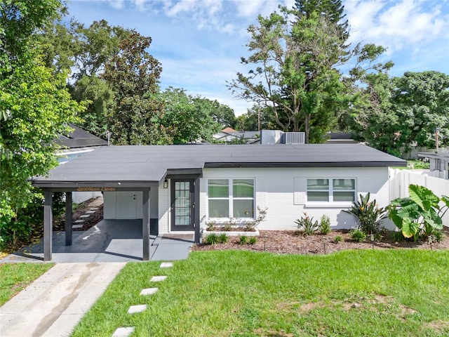 ranch-style home featuring a carport and a front lawn