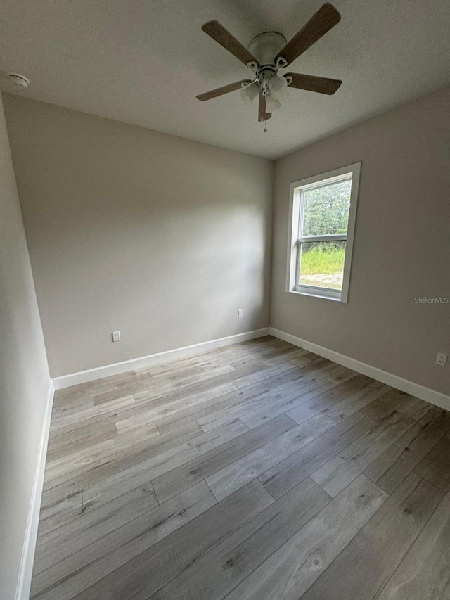 empty room with a textured ceiling, ceiling fan, and light hardwood / wood-style floors