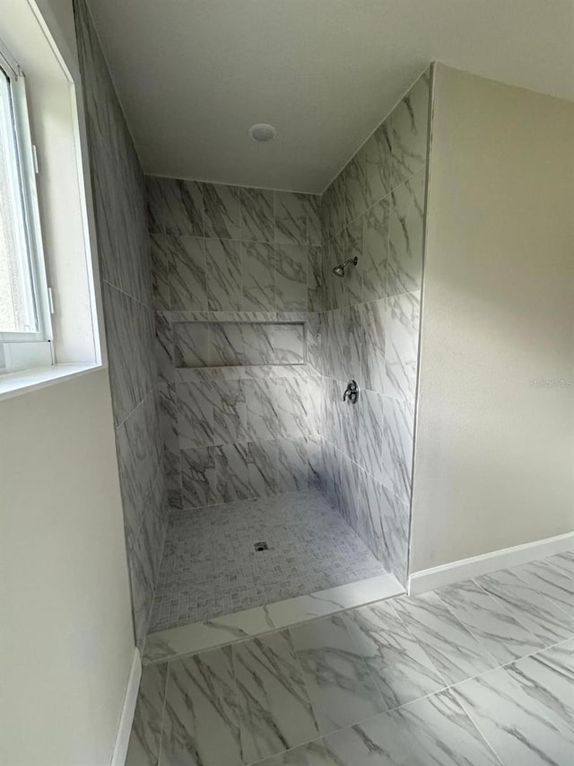 bathroom featuring a wealth of natural light and a tile shower