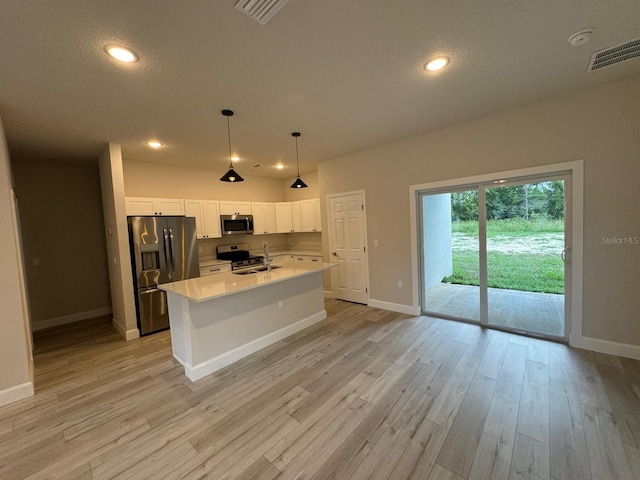 kitchen featuring an island with sink, stainless steel appliances, light wood-type flooring, and white cabinets