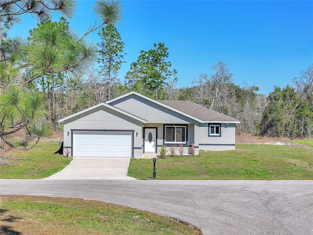 view of front of property featuring a garage, concrete driveway, a front lawn, and stucco siding