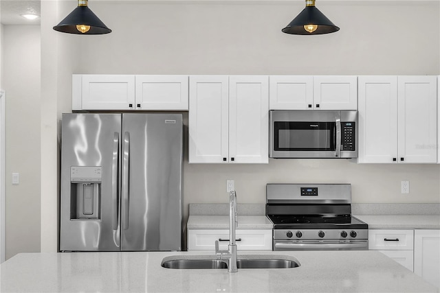 kitchen with white cabinetry, stainless steel appliances, and a sink