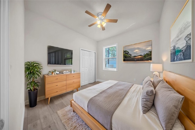 bedroom featuring light wood-style floors, a closet, ceiling fan, and baseboards