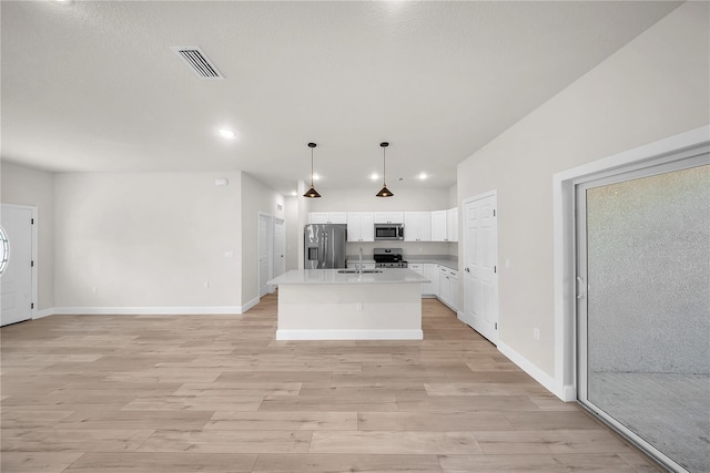 kitchen with light wood finished floors, visible vents, white cabinets, stainless steel appliances, and light countertops