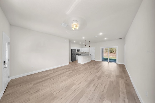 unfurnished living room featuring recessed lighting, visible vents, light wood-style flooring, and baseboards